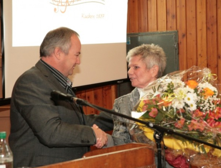 Uwe Lövesz überreicht Helge Mühlich der Vorsitzenden der Germania die besten Glückwünsche